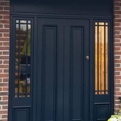 Dark blue double front door with decorative panels and narrow glass grille windows on both sides in a brick facade.